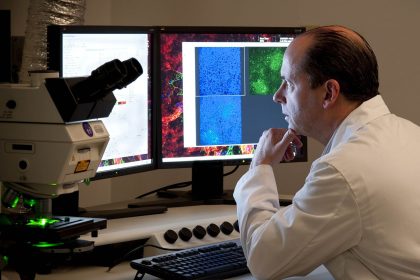 A researcher looking through a microscope in a laboratory