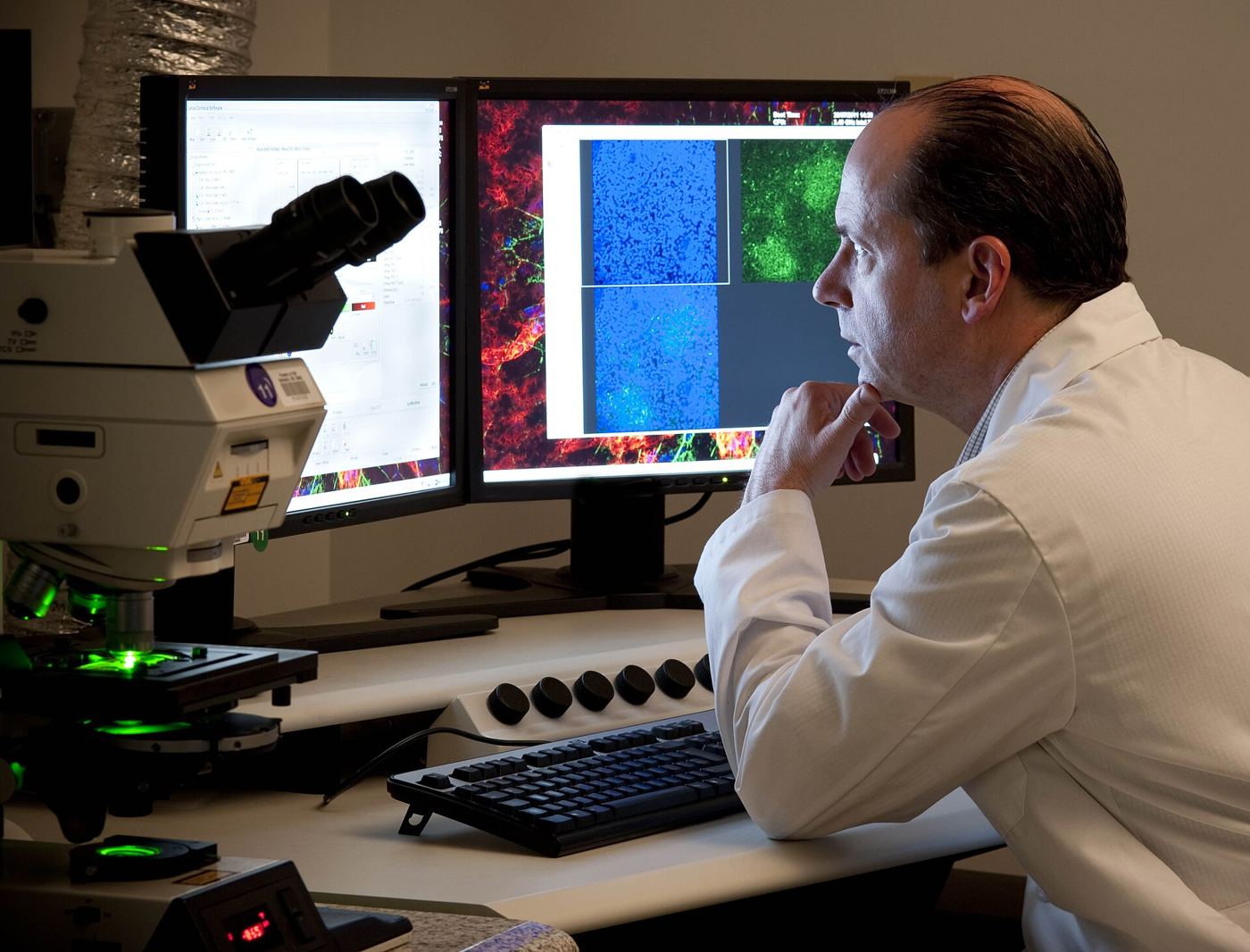 A researcher looking through a microscope in a laboratory