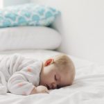 A person sleeps peacefully in a dark, quiet bedroom at night.