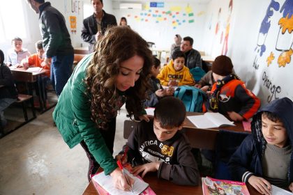 Teacher helping pupils during a lesson in a modern classroom